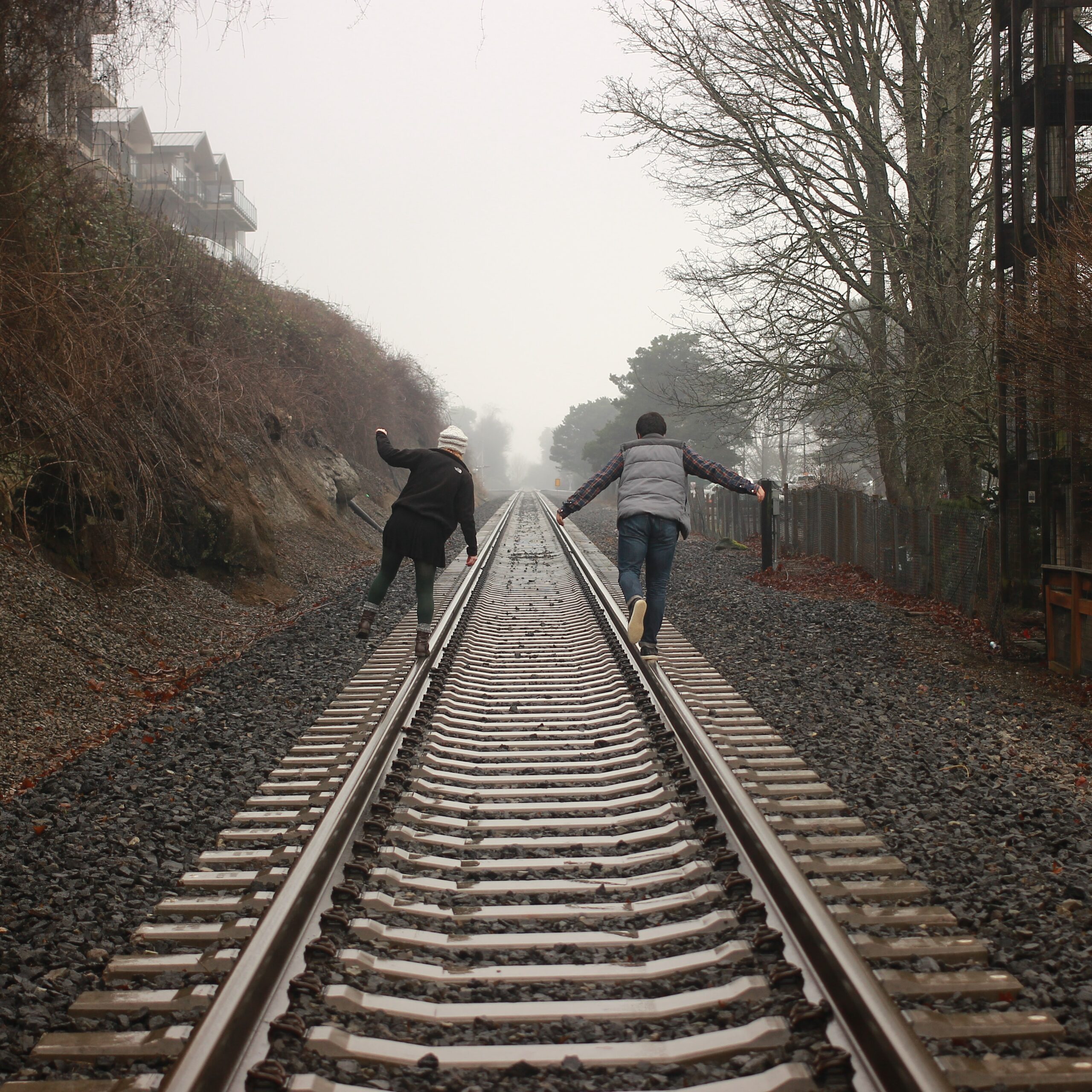 2 people balancing on railroad tracks